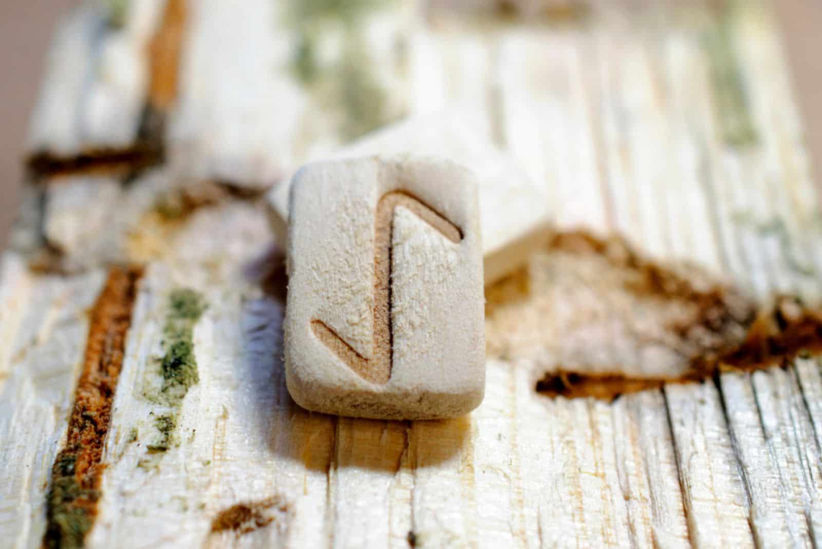 Rune en bois Eihwaz gros plan sur un fond en bois