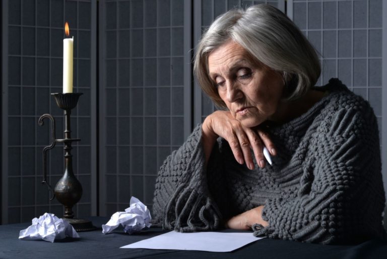 triste femme âgée écrivant une lettre à son fils
