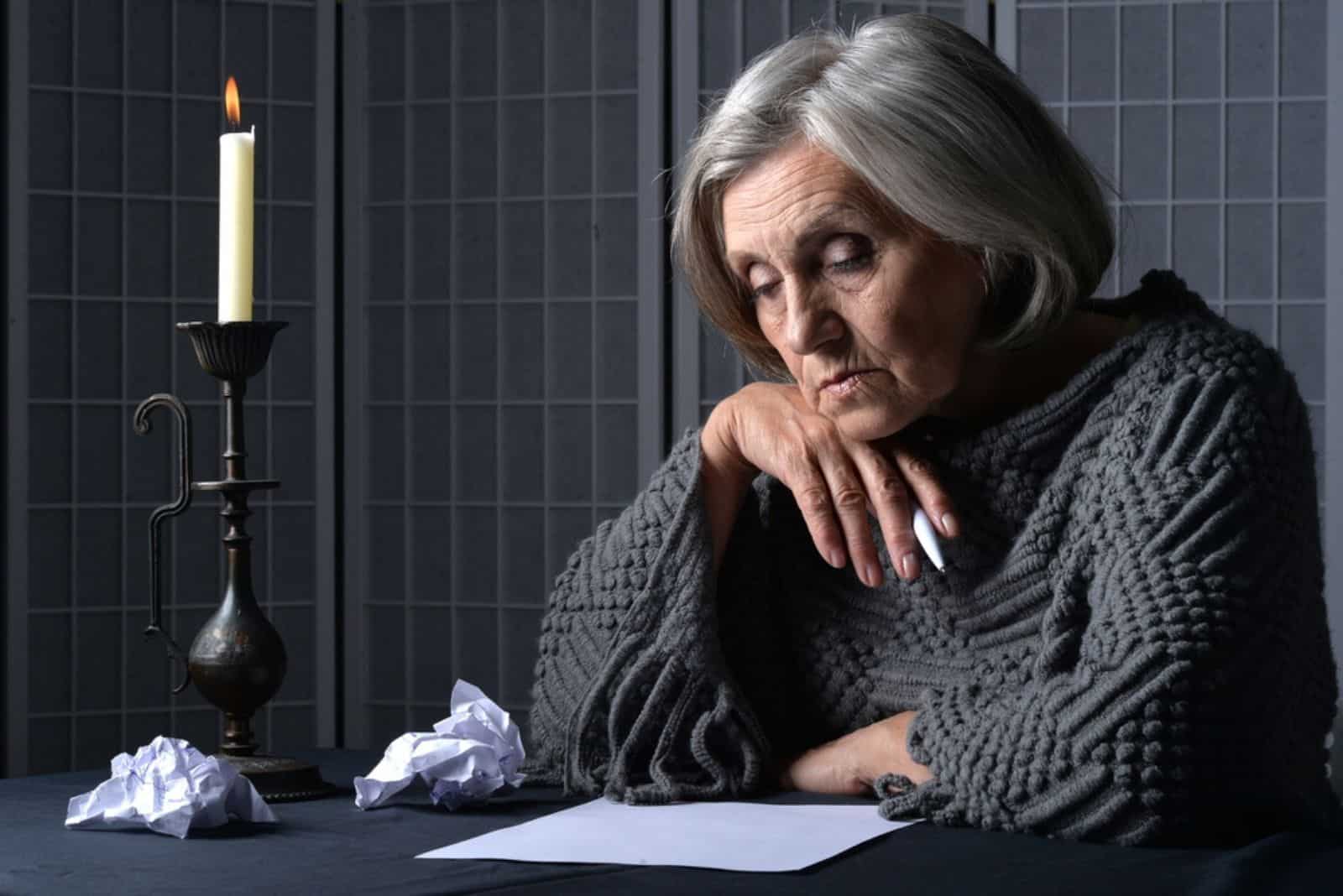 triste femme âgée écrivant une lettre à son fils