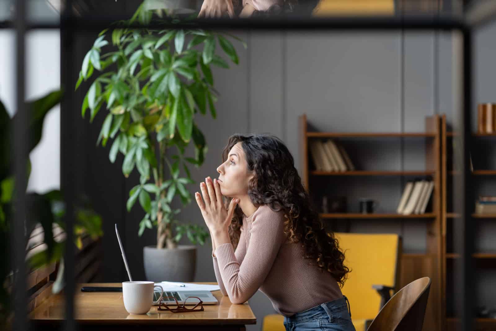 femme non motivée priant au bureau