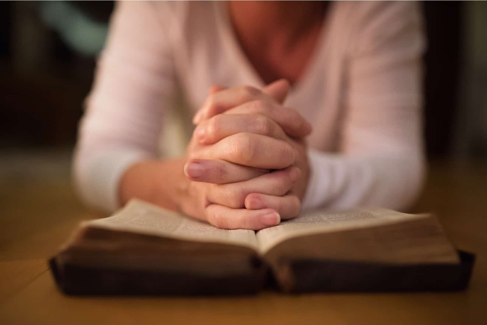 femme priant avec la bible ouverte