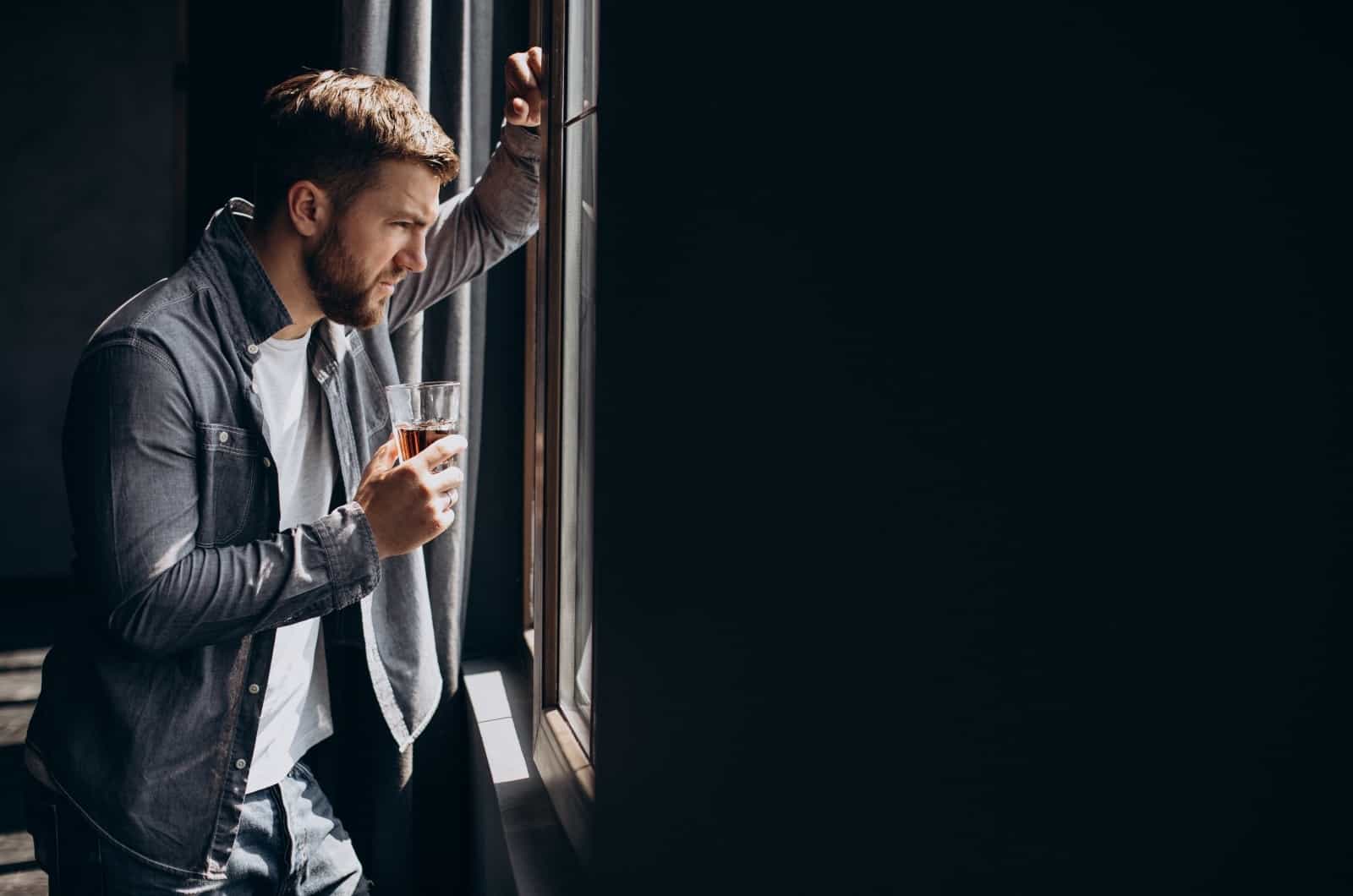 homme ivre regardant par la fenêtre