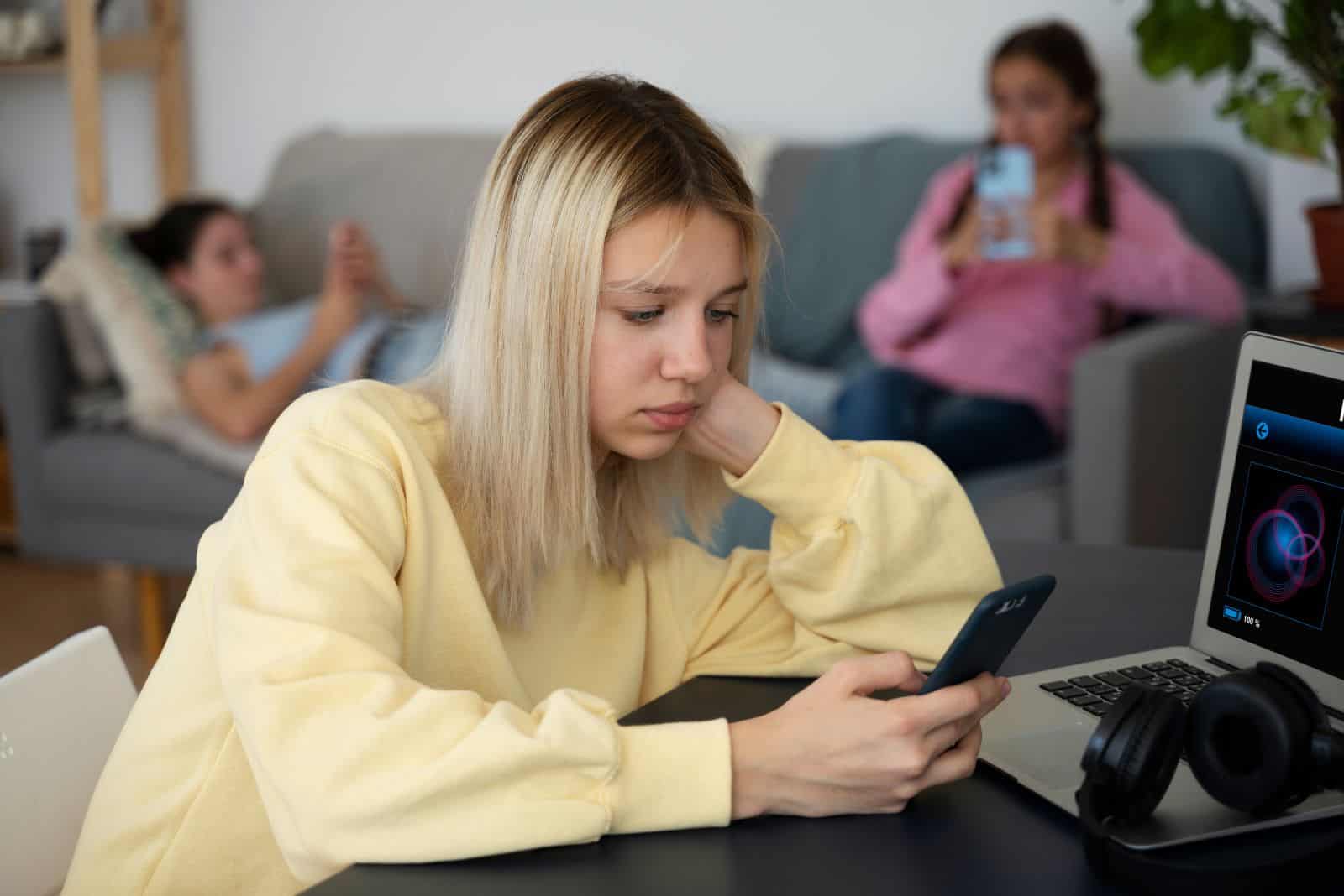 jeune fille blonde tenant un smartphone