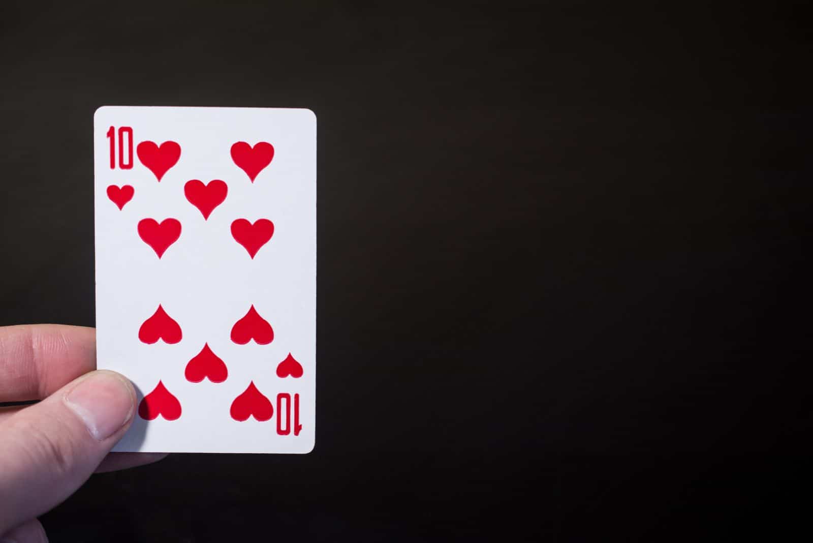 un coeur de dix cartes dans la main d'un homme