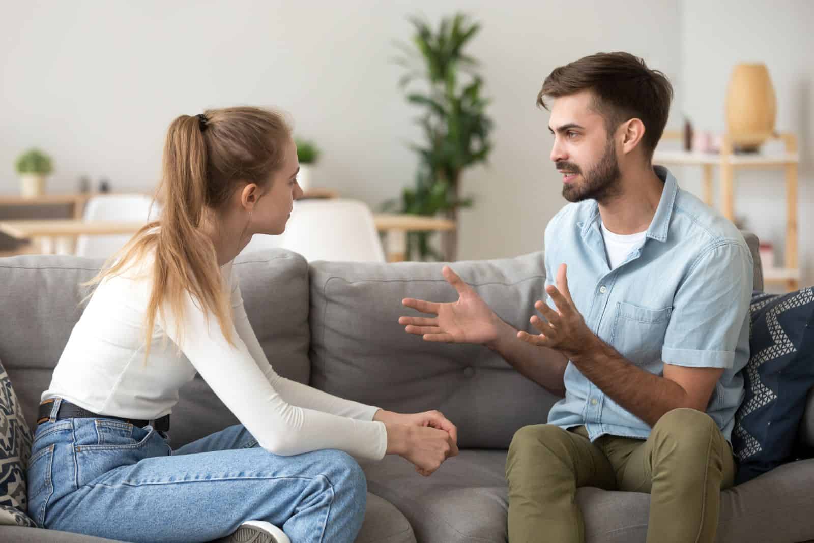 un homme et une femme sont assis sur le canapé et se disputent