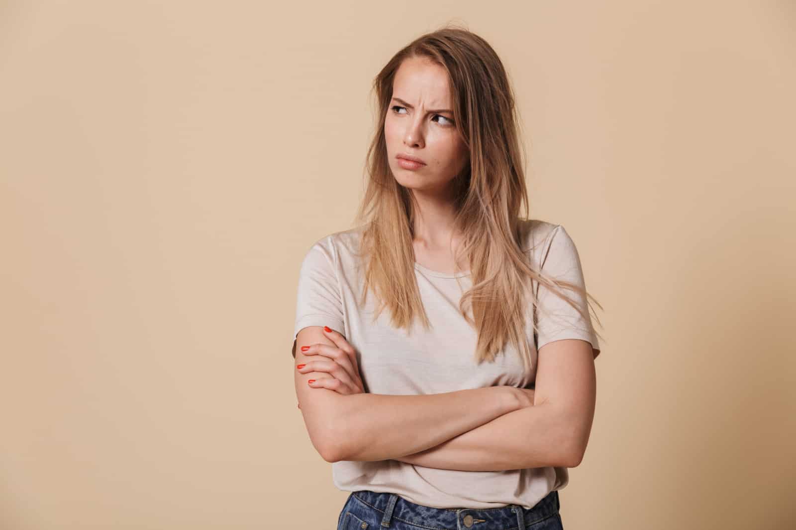 portrait d'une jeune femme en colère regardant sur le côté avec les bras croisés