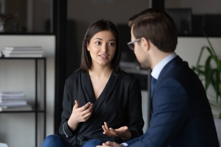 un homme et une femme sont assis au bureau et parlent