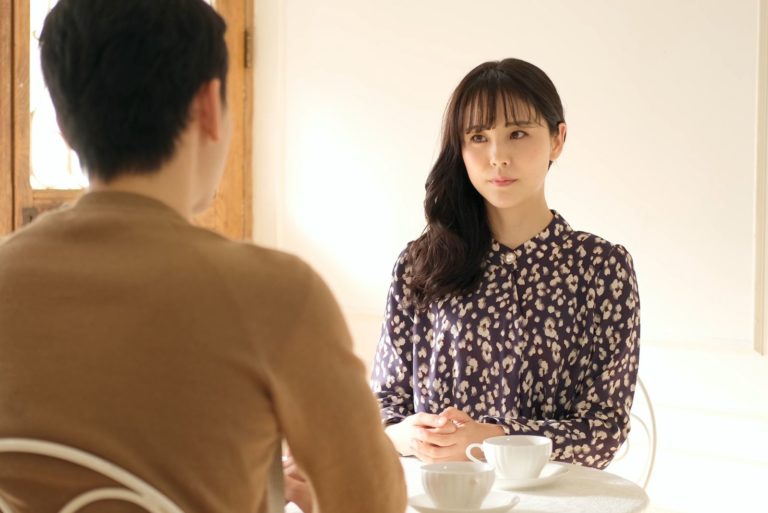 une belle fille est assise à une table et parle à un homme