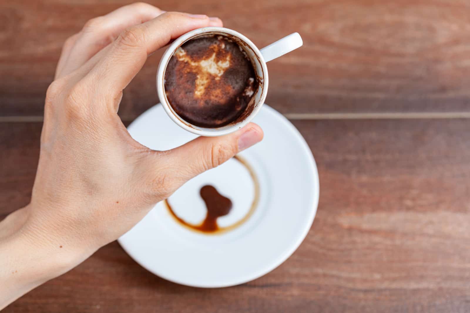 Une femme caucasienne effectue une lecture de fortune ( kahve fali ) en utilisant des restes de marc de café dans une tasse de café turque en céramique