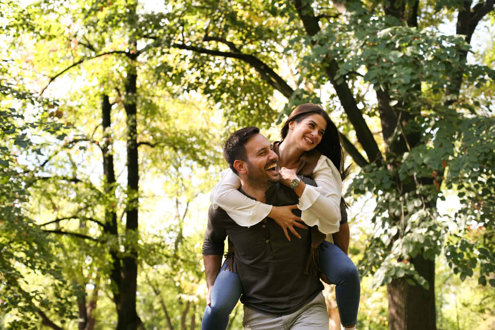 couple heureux à l'extérieur dans les bois s'amusant