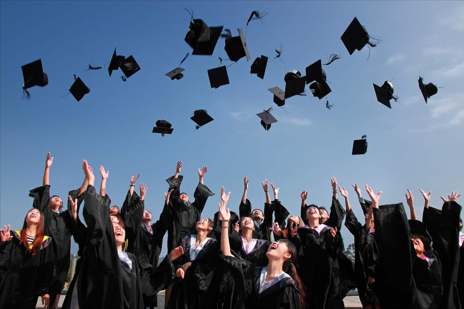 diplômés jetant des chapeaux en l'air