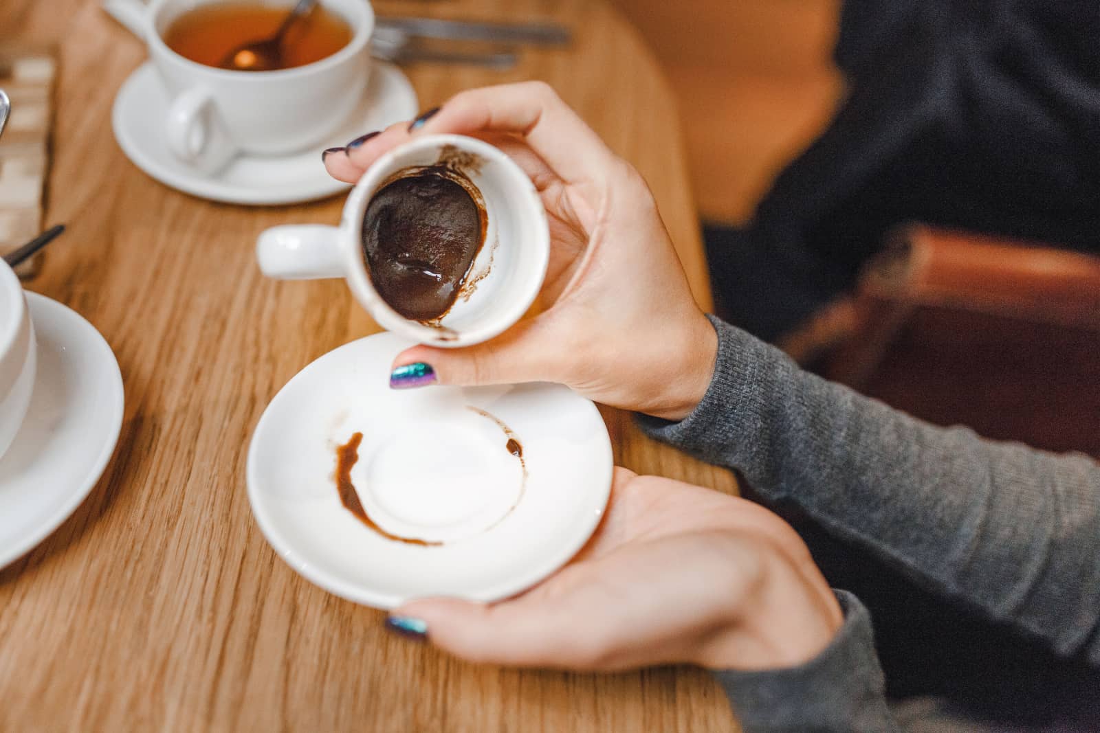 femme regardant du marc de café dans une tasse pour dire la bonne aventure