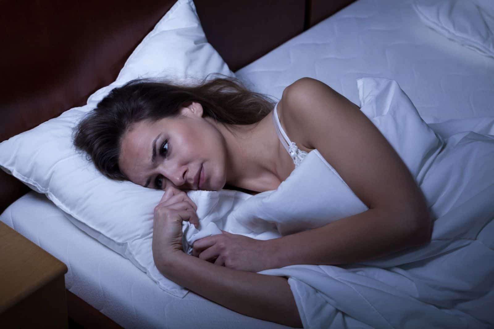 Femme souffrant d'insomnie allongée dans son lit