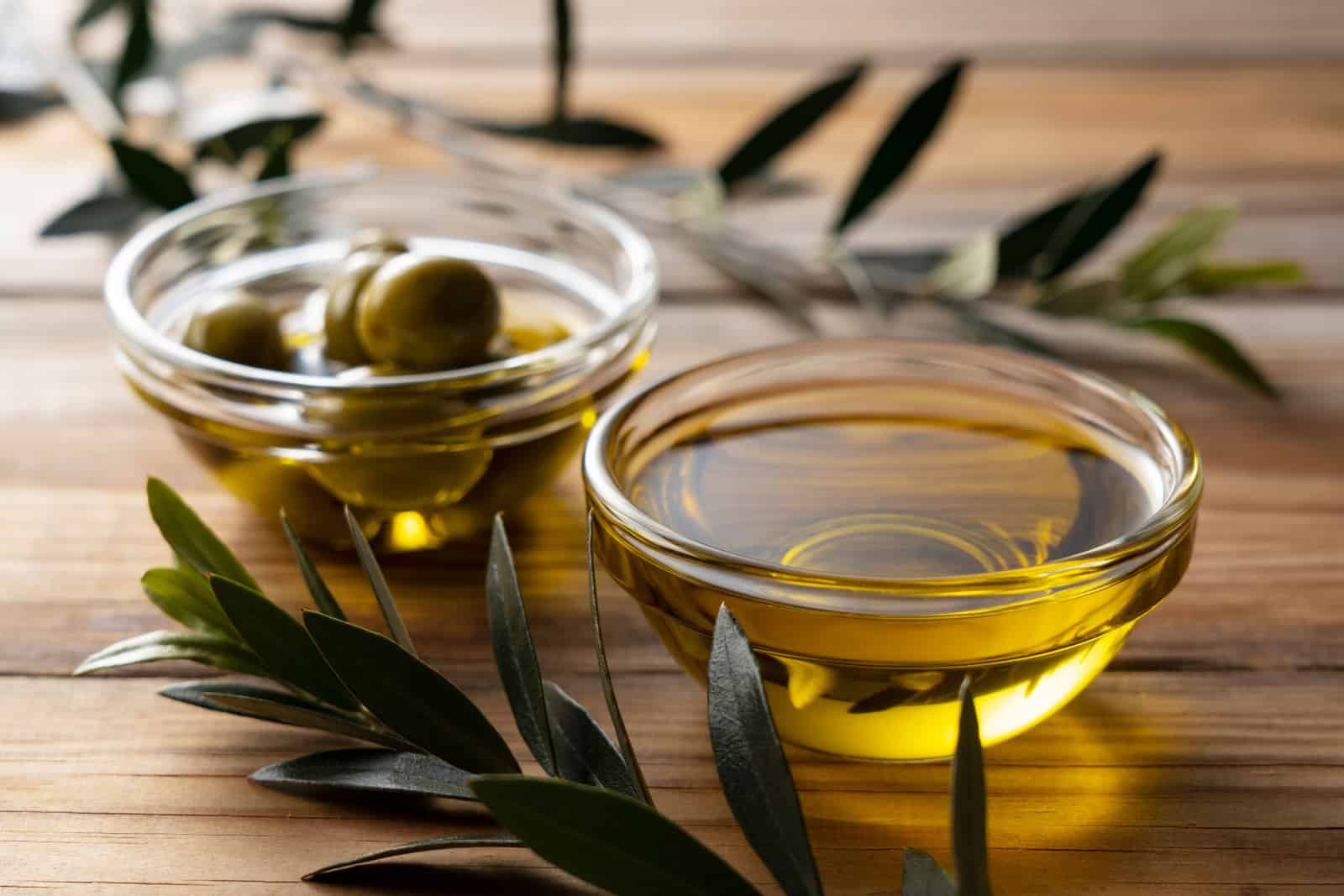 L'huile d'olive dans un bol en verre sur un fond de bois