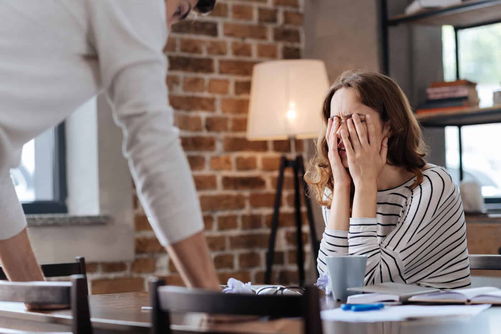 femme couvre son visage tout en se battant avec son petit ami