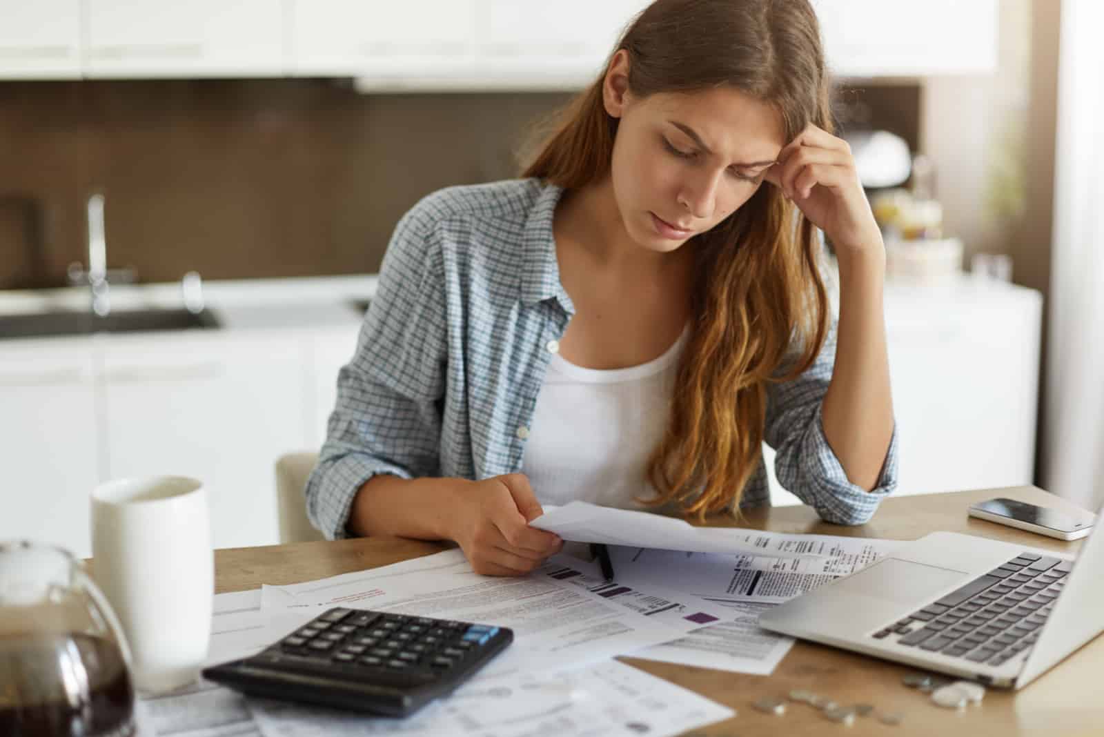 femme inquiète regardant des papiers financiers