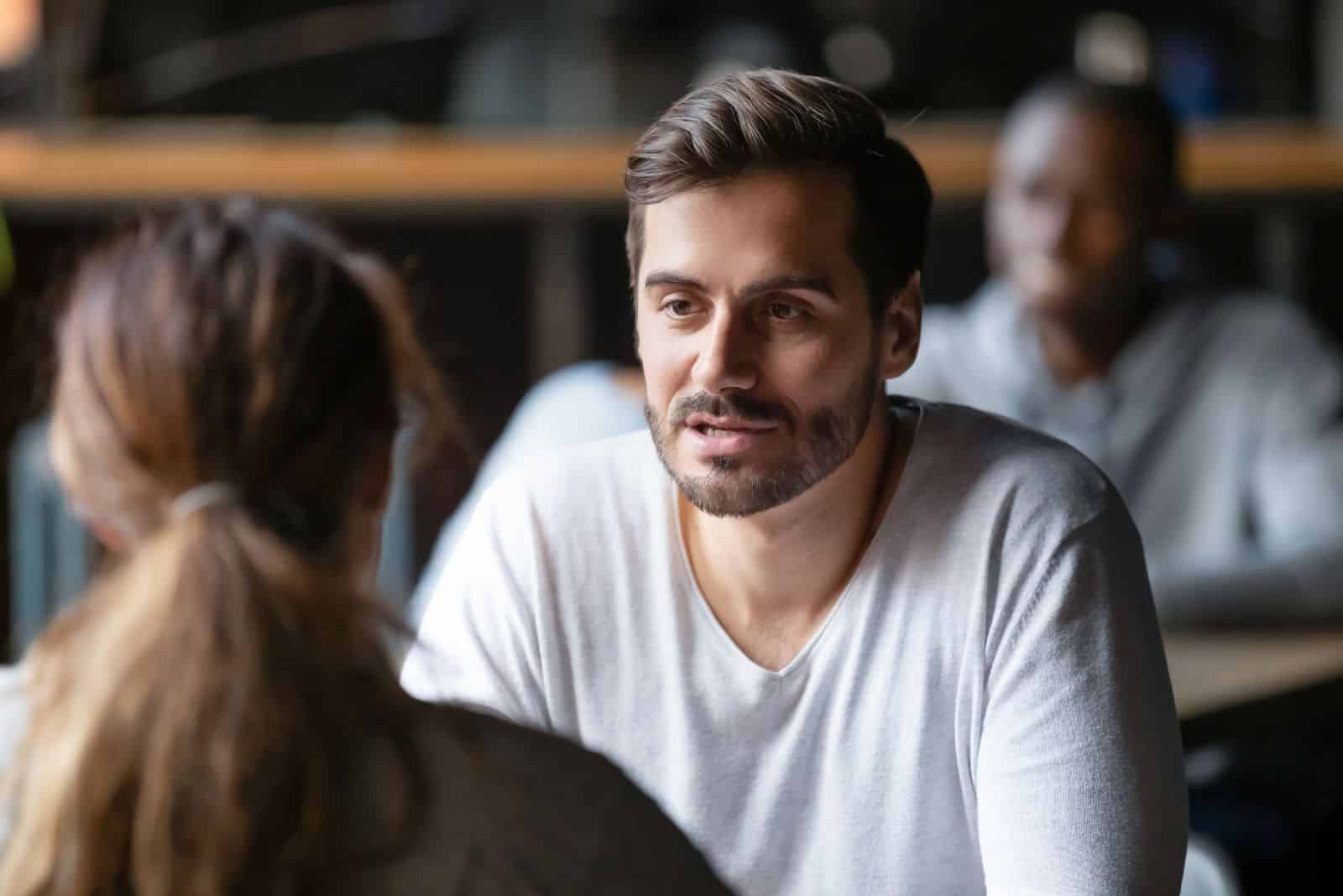 un homme parle à une femme à table