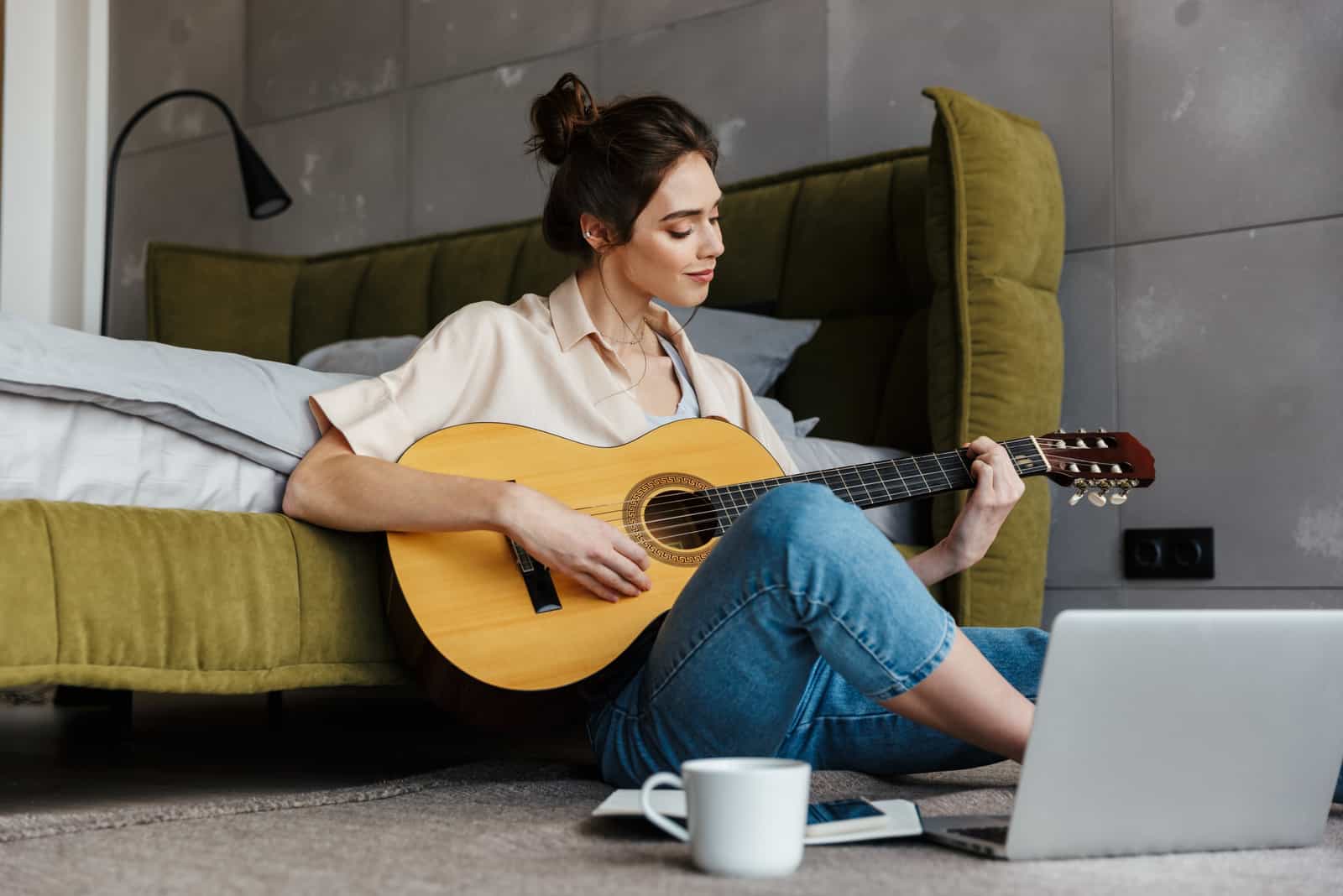 photo d'une femme jouant de la guitare sur le sol