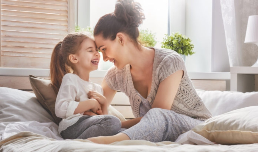 maman et sa jeune fille riant au lit