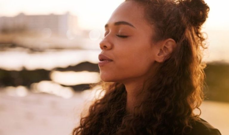 jeune femme assise seule sur une natte et meditant