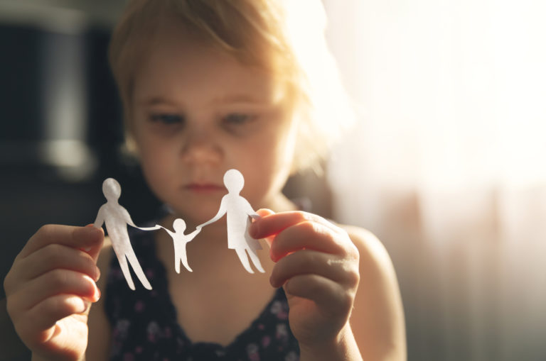 petit enfant tenant une découpe de papier d'une famille