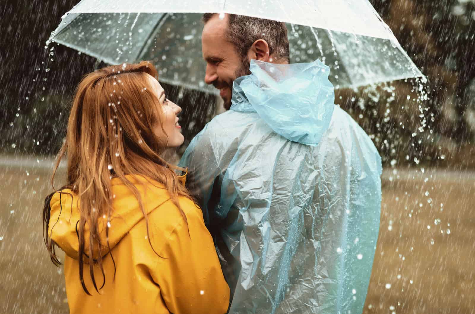 beau couple debout sous la pluie sous un parapluie