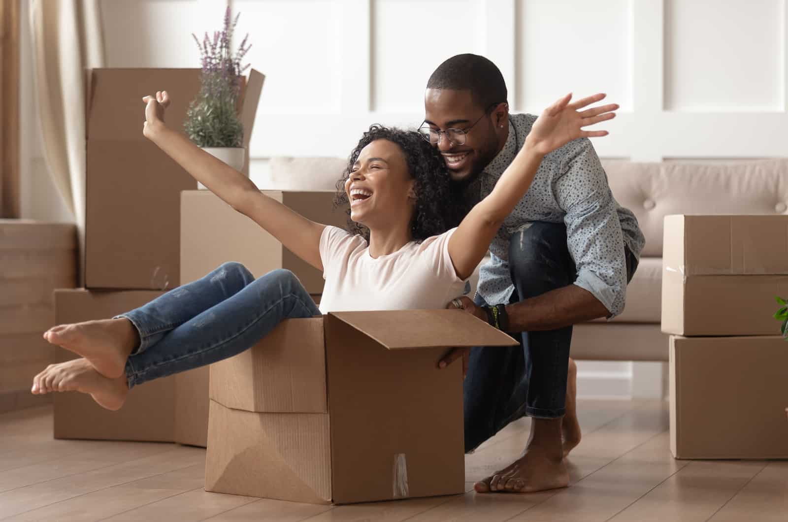 couple heureux jouant avec des cartons de déménagement