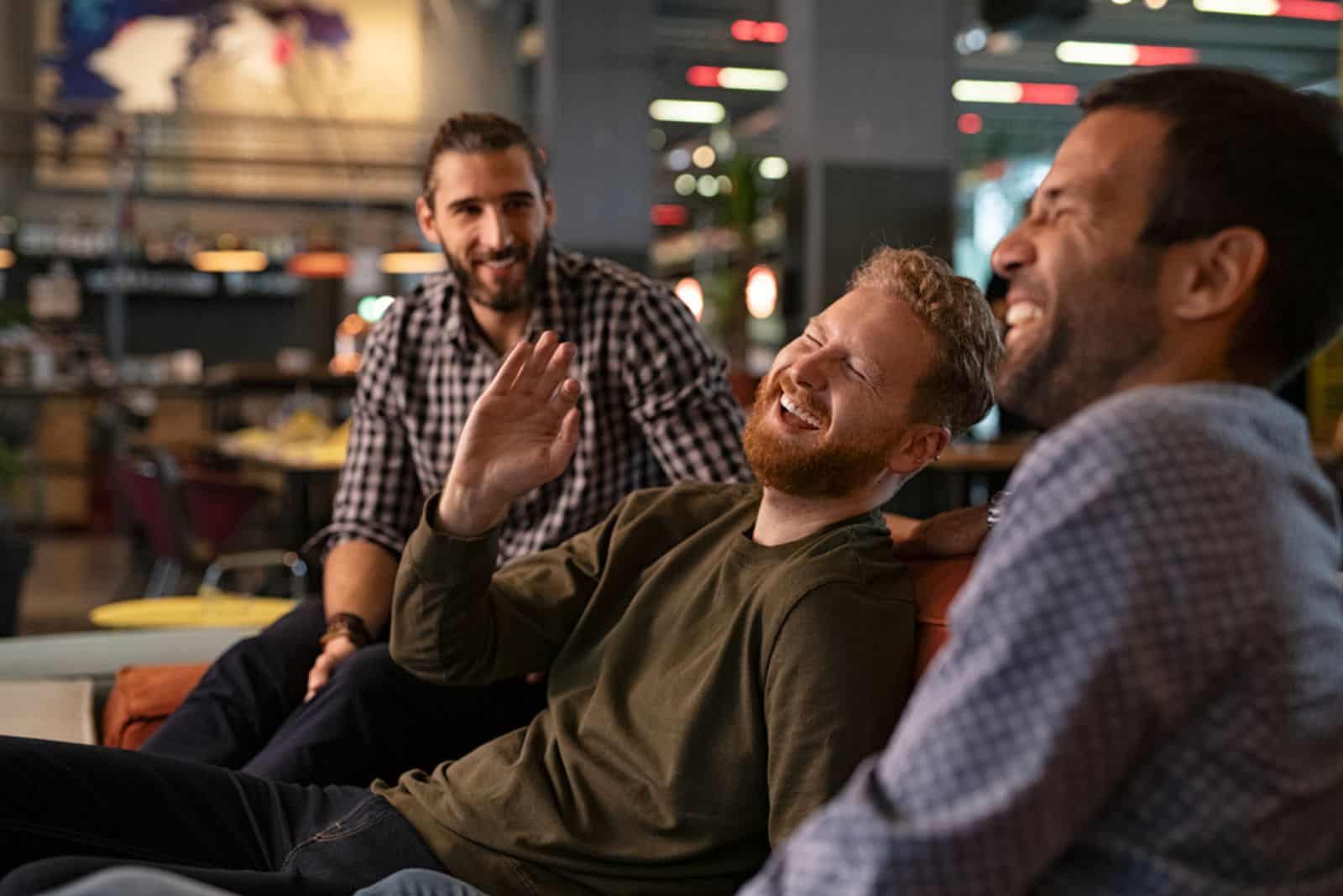 trois meilleurs amis riant et profitant de la soirée au pub