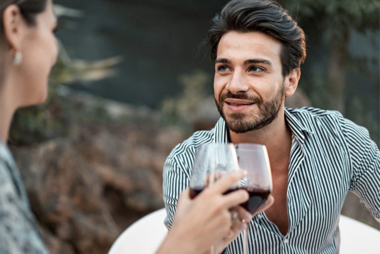 jeune couple buvant du vin et assis dehors