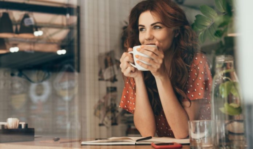 une belle femme tient une tasse a la main