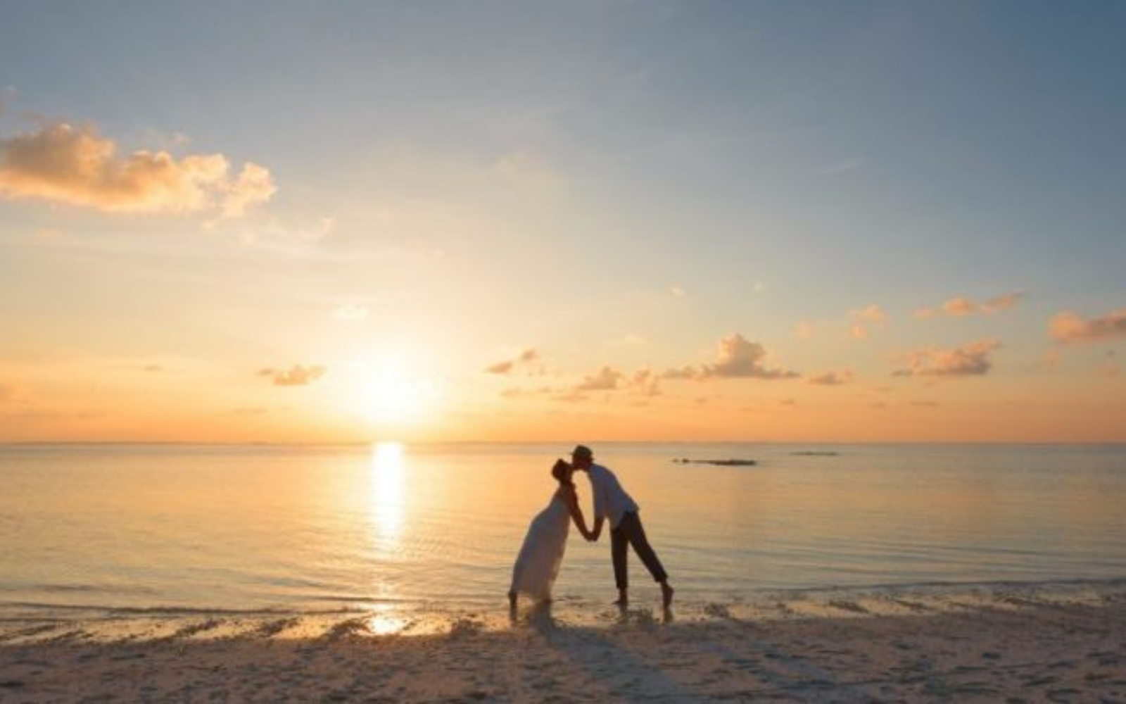 un homme et une femme sembrassant sur la plage