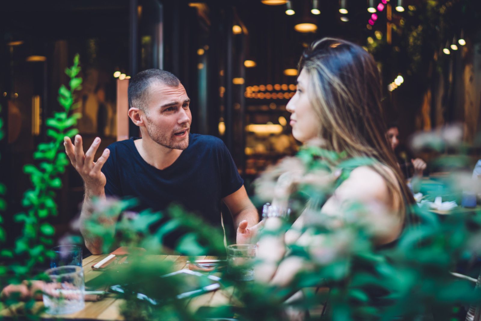 un homme et une femme se disputent dans un restaurant à table