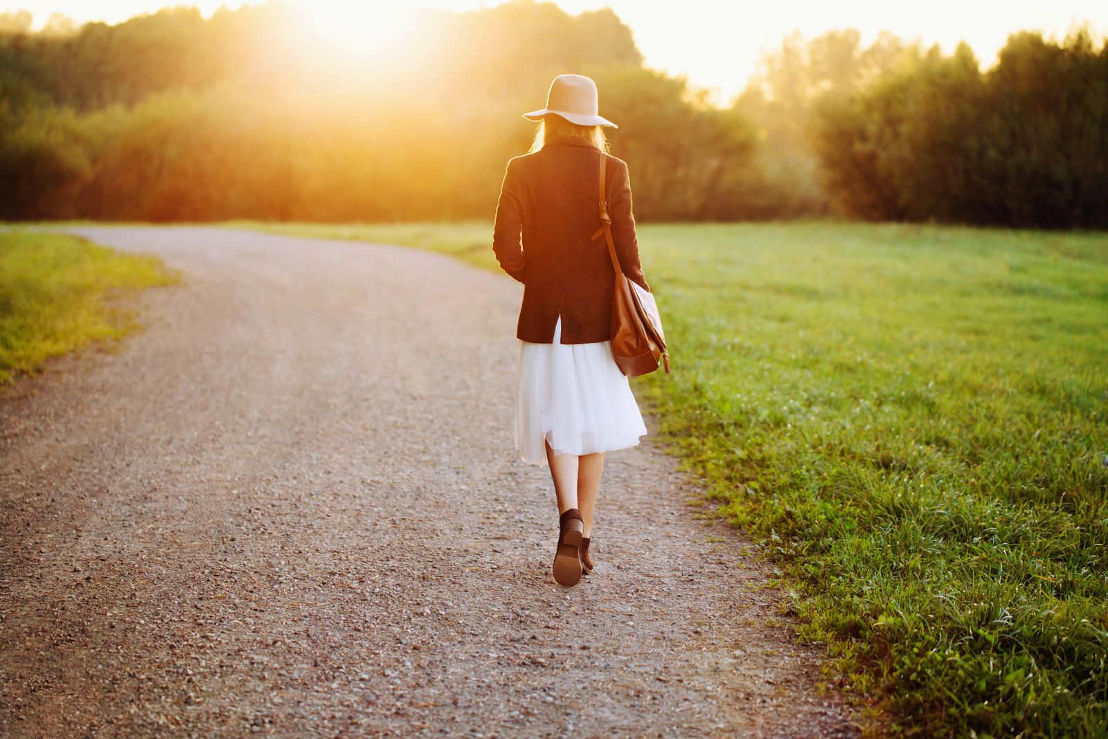une femme avec un chapeau se promène dans le parc en automne