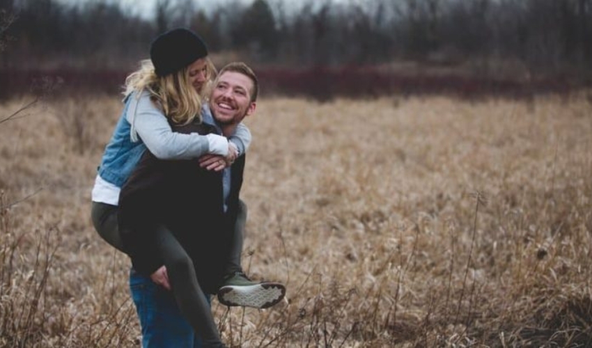 un homme porte une femme et rit