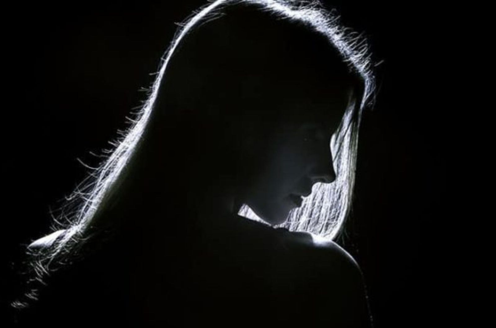 silhouette dune jeune femme triste dans lobscurite