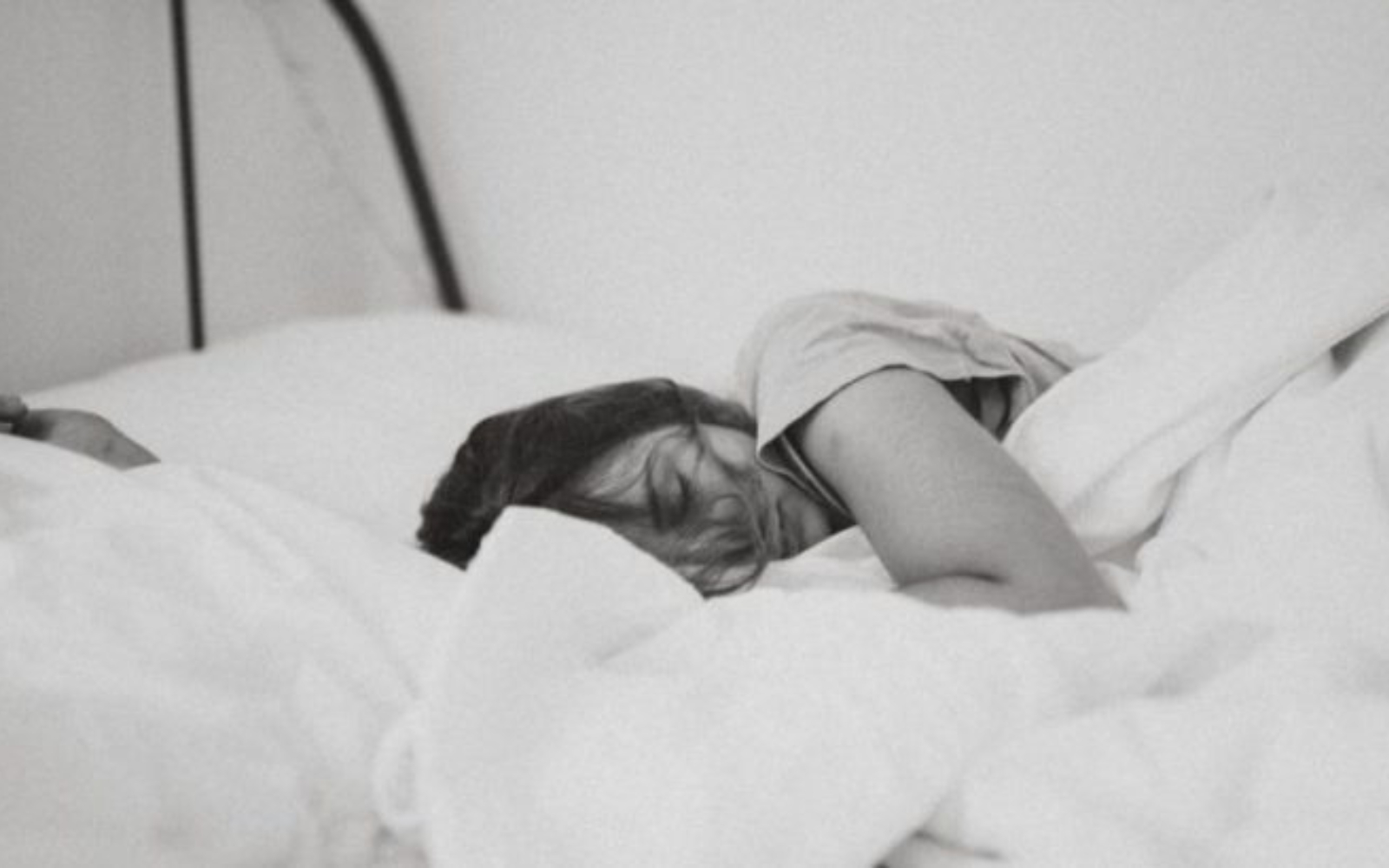 une femme fatiguee couchee dans son lit