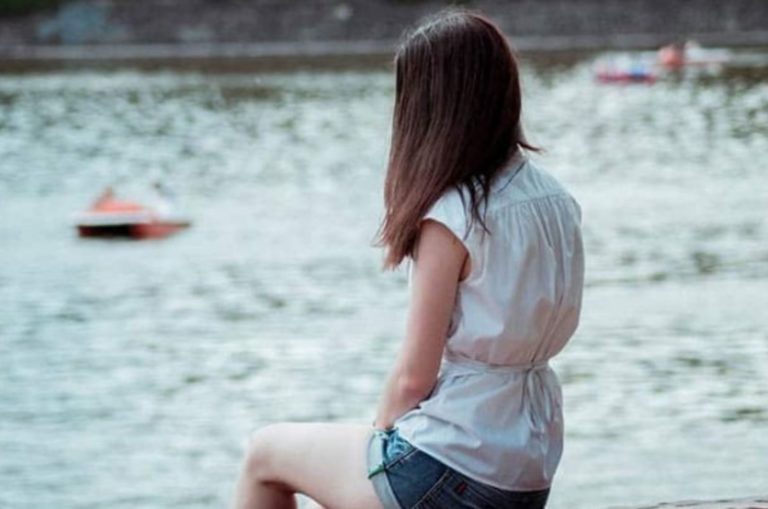 la femme est assise sur un banc