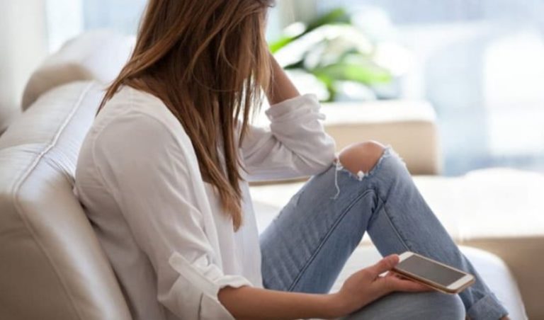 femme triste tenant un telephone
