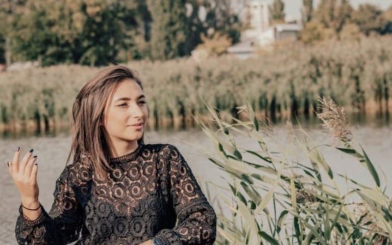 une femme aux cheveux bruns se tient dans un champ