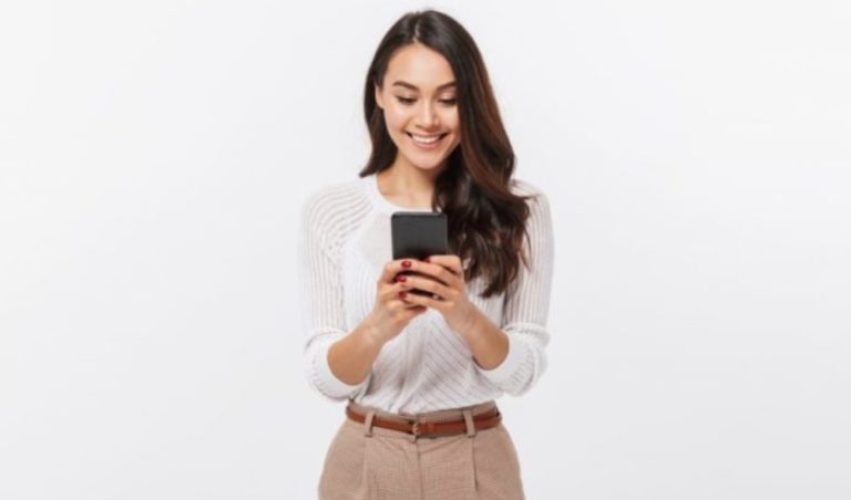 une femme debout avec un telephone a la main