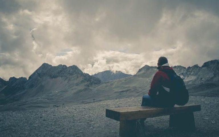 homme assis sur un banc profitant de la vue