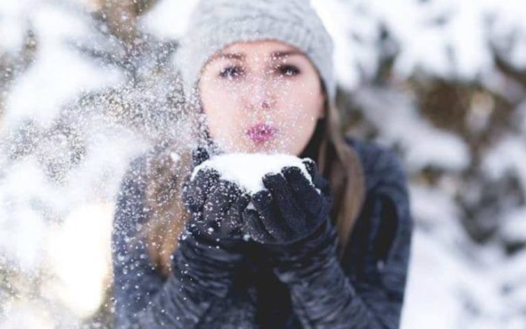 la femme souffle la neige de sa main