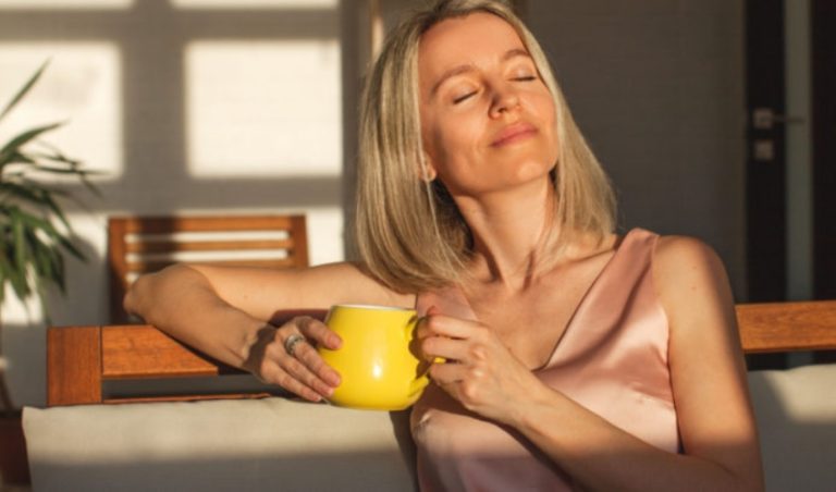 femme paisible aux yeux fermes tenant une tasse