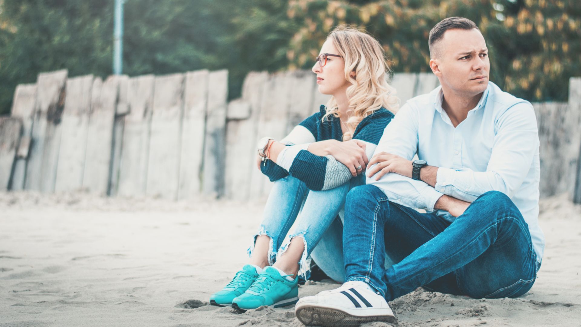 un homme et une femme sont assis l'un à côté de l'autre sur la plage et se taisent