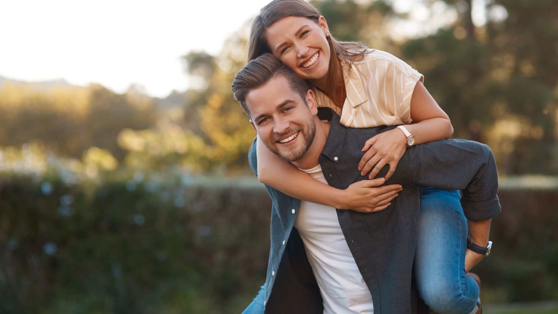 un homme souriant porte une femme