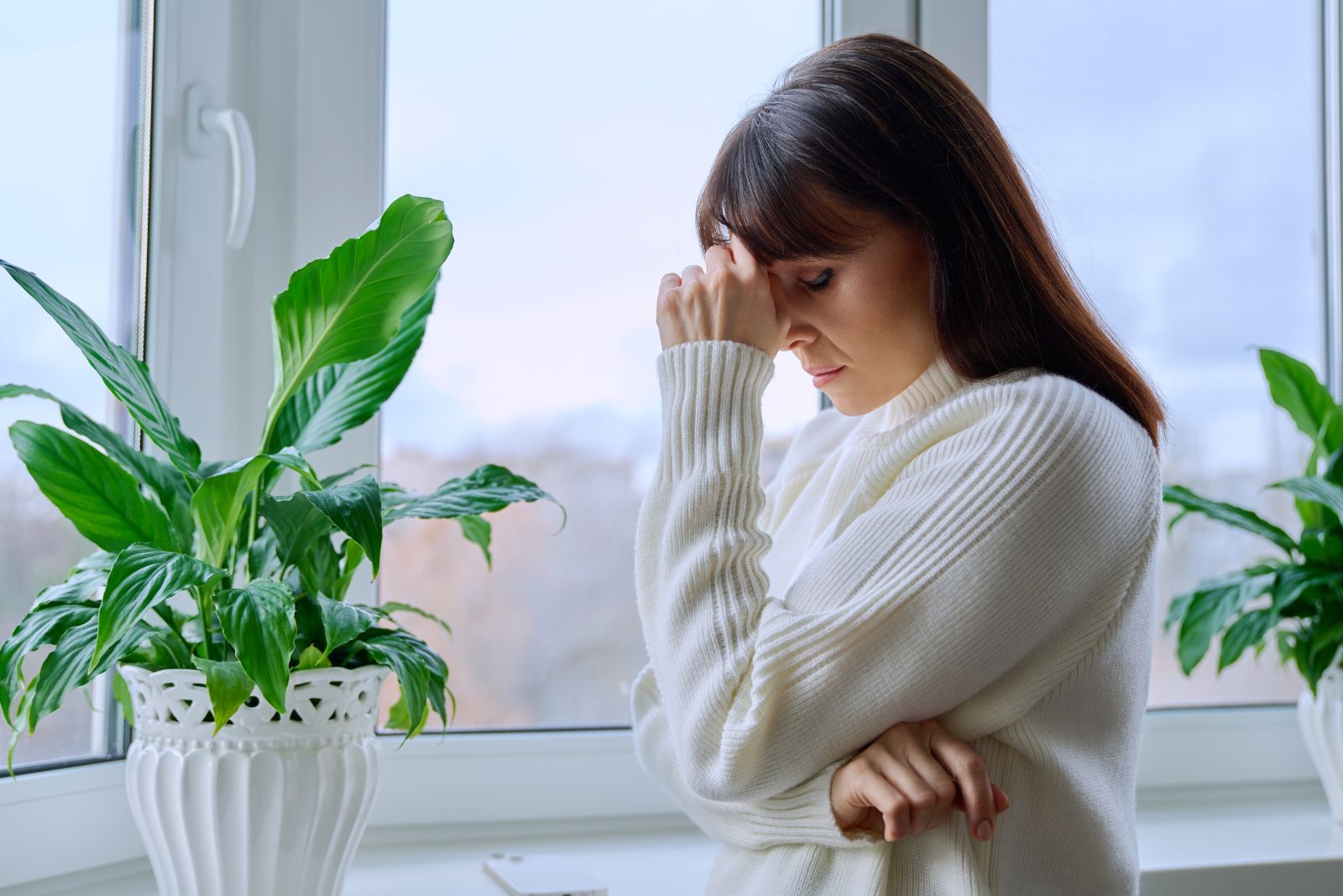 femme inquiete debout avec la main sur le front