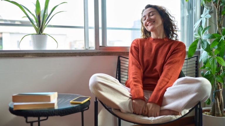 une fille souriante est assise sur une chaise