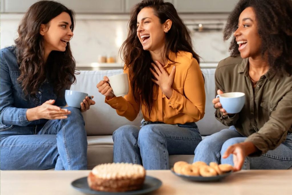 amies souriantes parlant autour d'un café