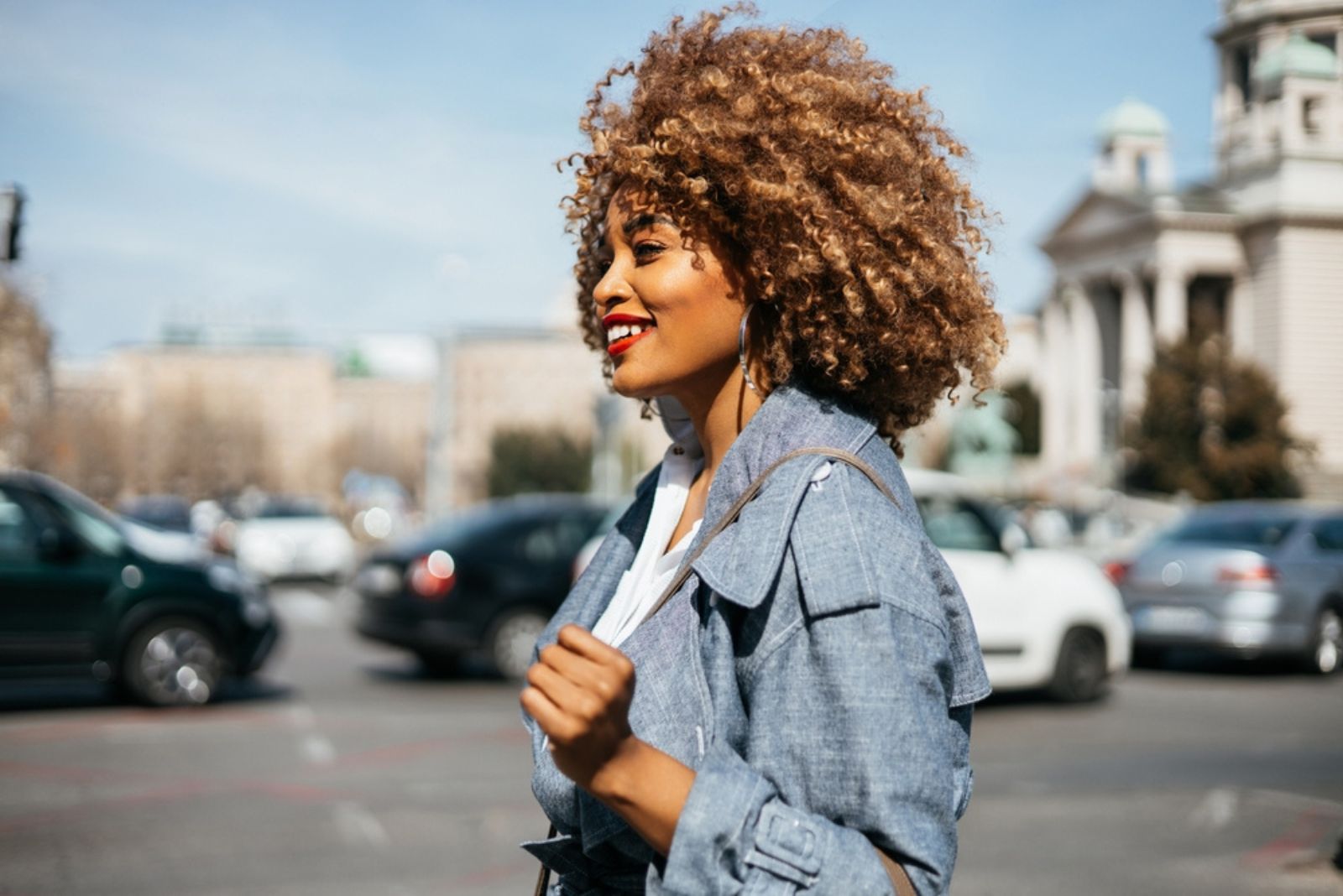 femme souriante aux cheveux bouclés en plein air