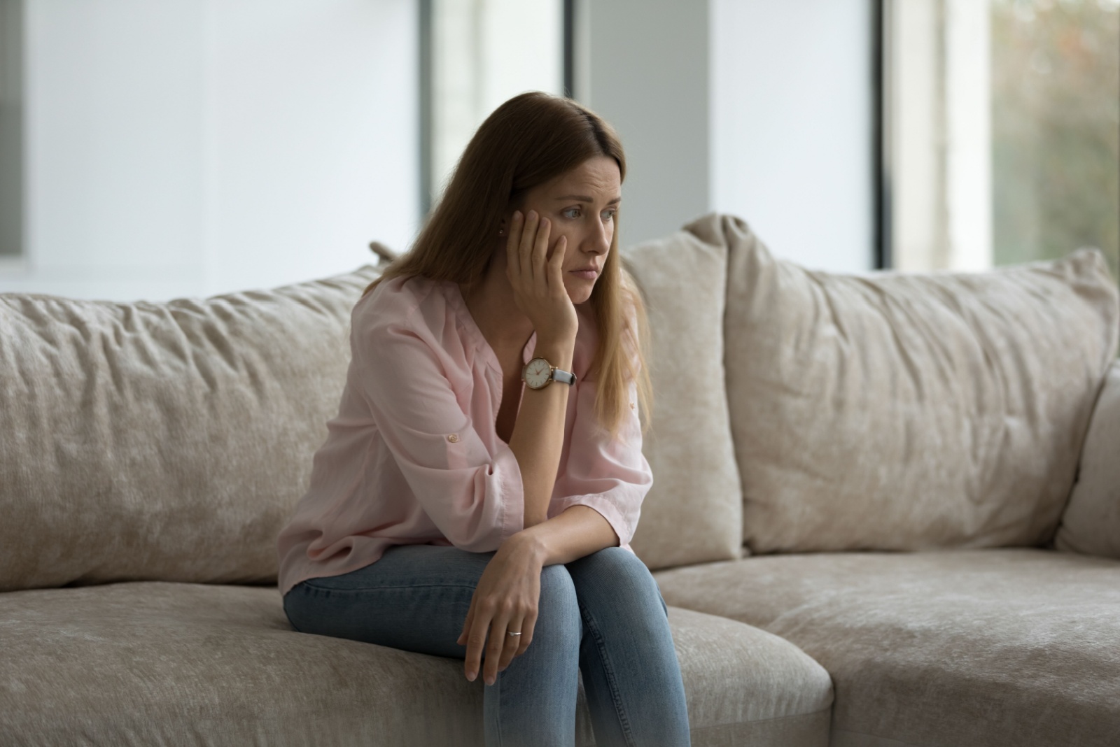 femme triste assise sur le canape